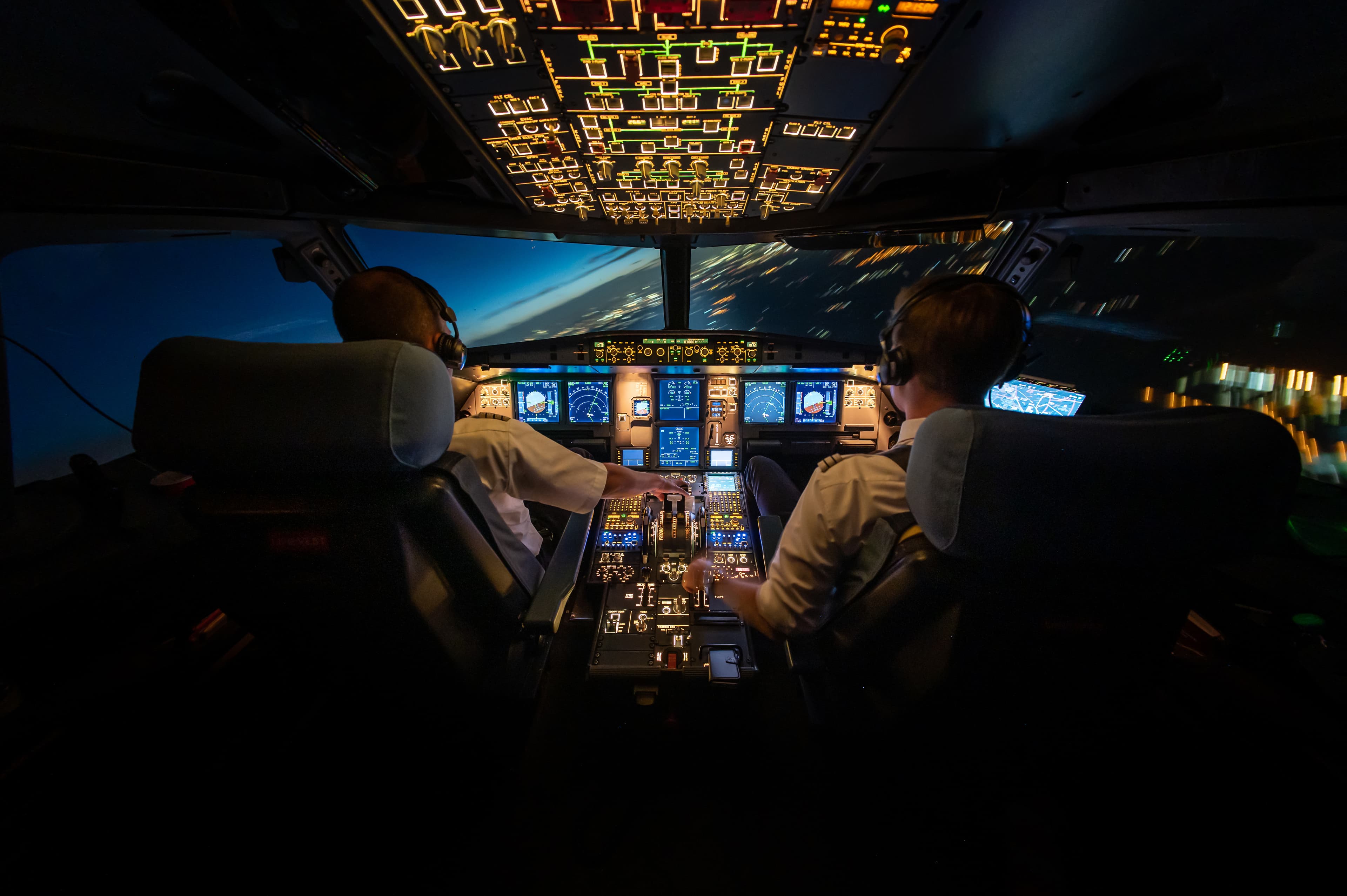Image of an airplane cockpit by night.